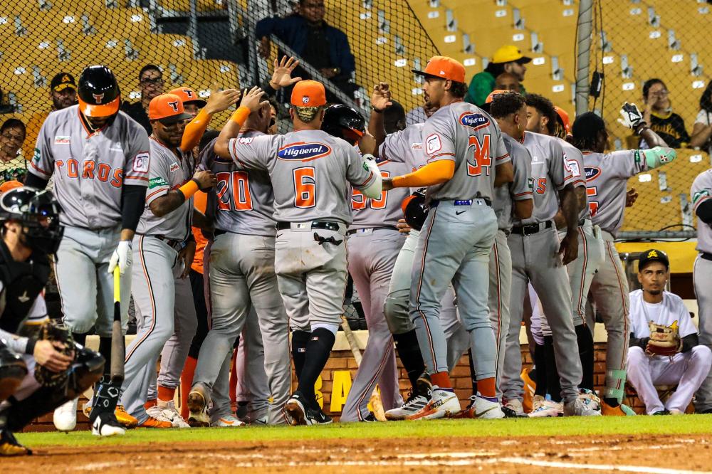 Jugadores de los Toros del Este celebran en el Estadio Cibao tras el cuadrangular de Felnin Celestén, durante la victoria 14-7 sobre las Águilas Cibaeñas en la jornada del viernes.